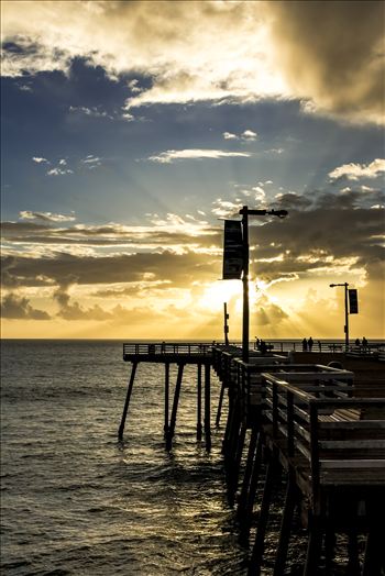 Sunset sun rays say good evening to Pismo Beach pier