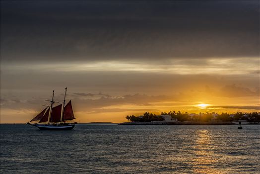 Key West sunset celebration with tall ships in the distance.