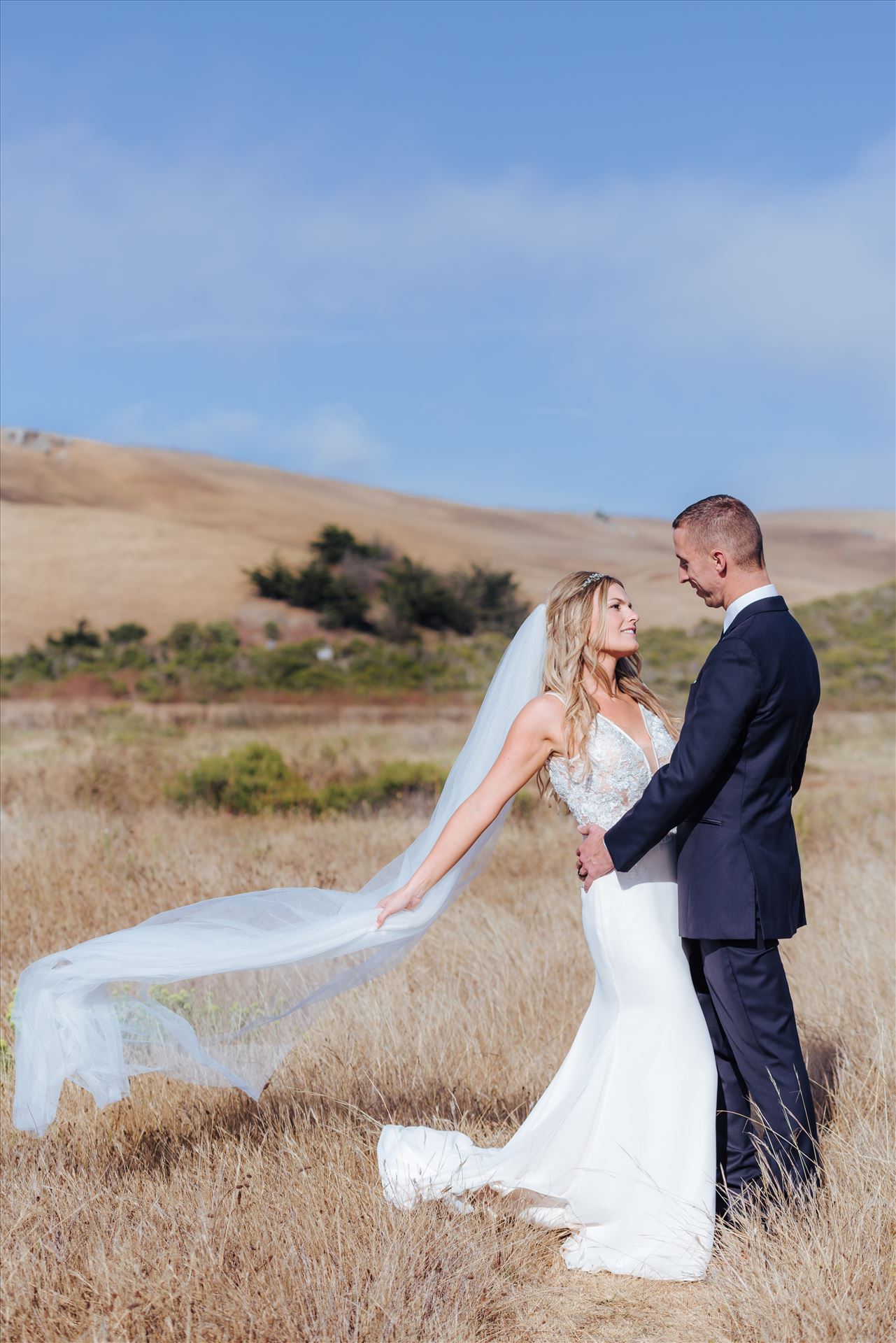 FW-0776.JPGCayucos California Beach and Bluffs Wedding near Morro Bay and Cambria with romantic chic flair by Mirror's Edge Photography, San Luis Obispo County Wedding Photographer.  Bride and Groom on the bluffs overlooking the ocean with veil flowing in the wind.