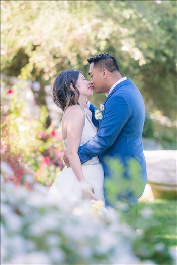 Mirror's Edge Photography captures Maryanne and Michael's magical wedding in the Secret Garden at the iconic Madonna Inn in San Luis Obispo, California.  Bride and Groom kiss in the garden