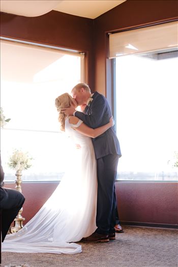 Sarah Williams of Mirror's Edge Photography, a San Luis Obispo Wedding and Engagement Photographer, captures Ryan and Joanna's wedding at the iconic Windows on the Water Restaurant in Morro Bay, California.  Bride and Groom kiss after I Do.