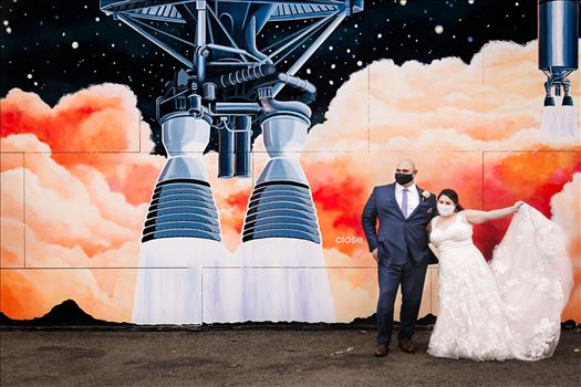 Sarah Williams of Mirror's Edge Photography and San Luis Obispo and Santa Barbara Wedding Photographer captures the Ochoa Wedding. Bride and Groom with Covid 19 Masks at Rocket Mural in Lompoc California.