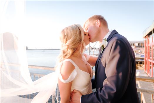 Sarah Williams of Mirror's Edge Photography, a San Luis Obispo Wedding and Engagement Photographer, captures Ryan and Joanna's wedding at the iconic Windows on the Water Restaurant in Morro Bay, California.  Bride and Groom kiss with ocean in background