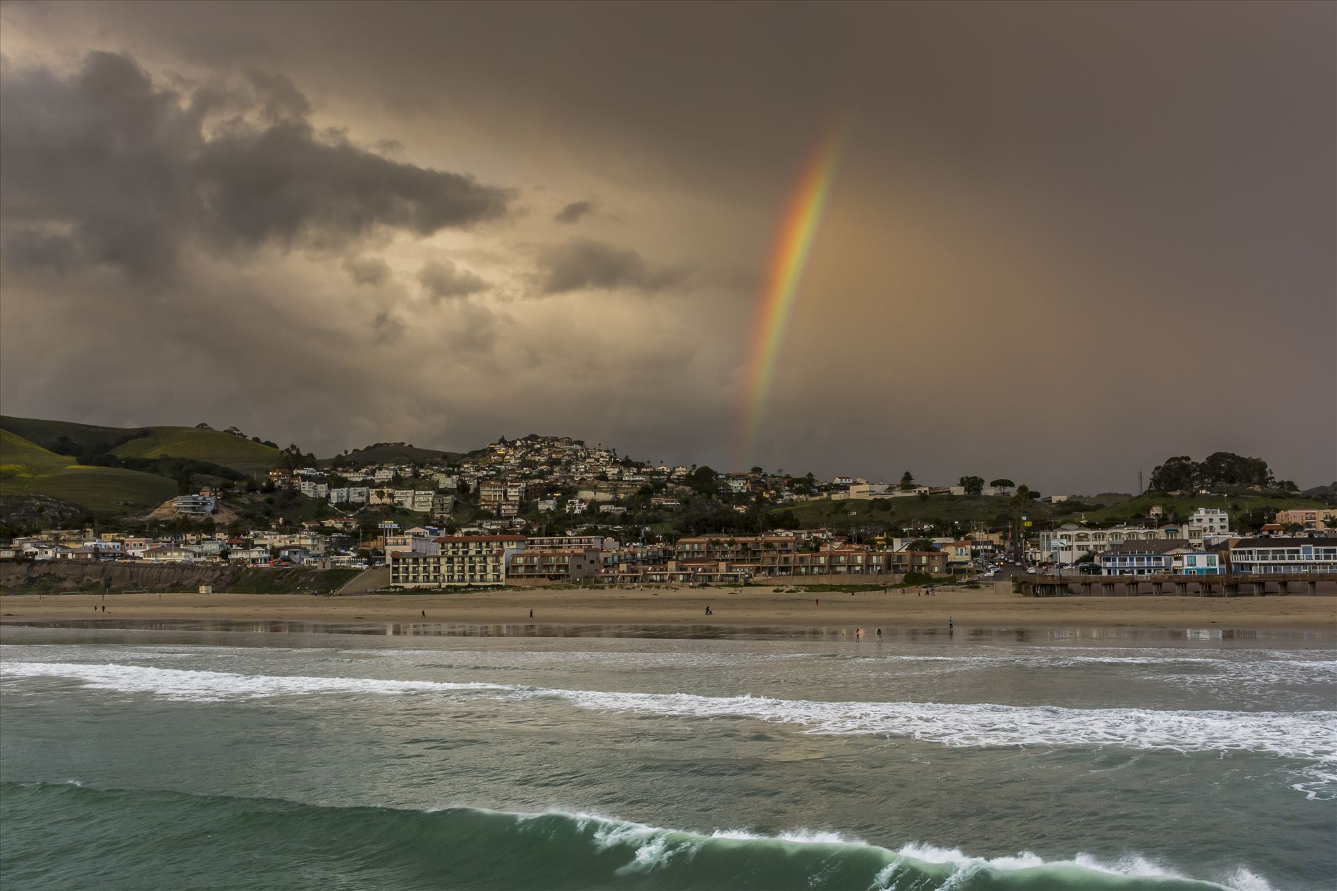 End of the Rainbow Pismo.jpg - Rainbow's end over downtown Pismo Beach - where ocean and sand meet stormy sky. by Sarah Williams
