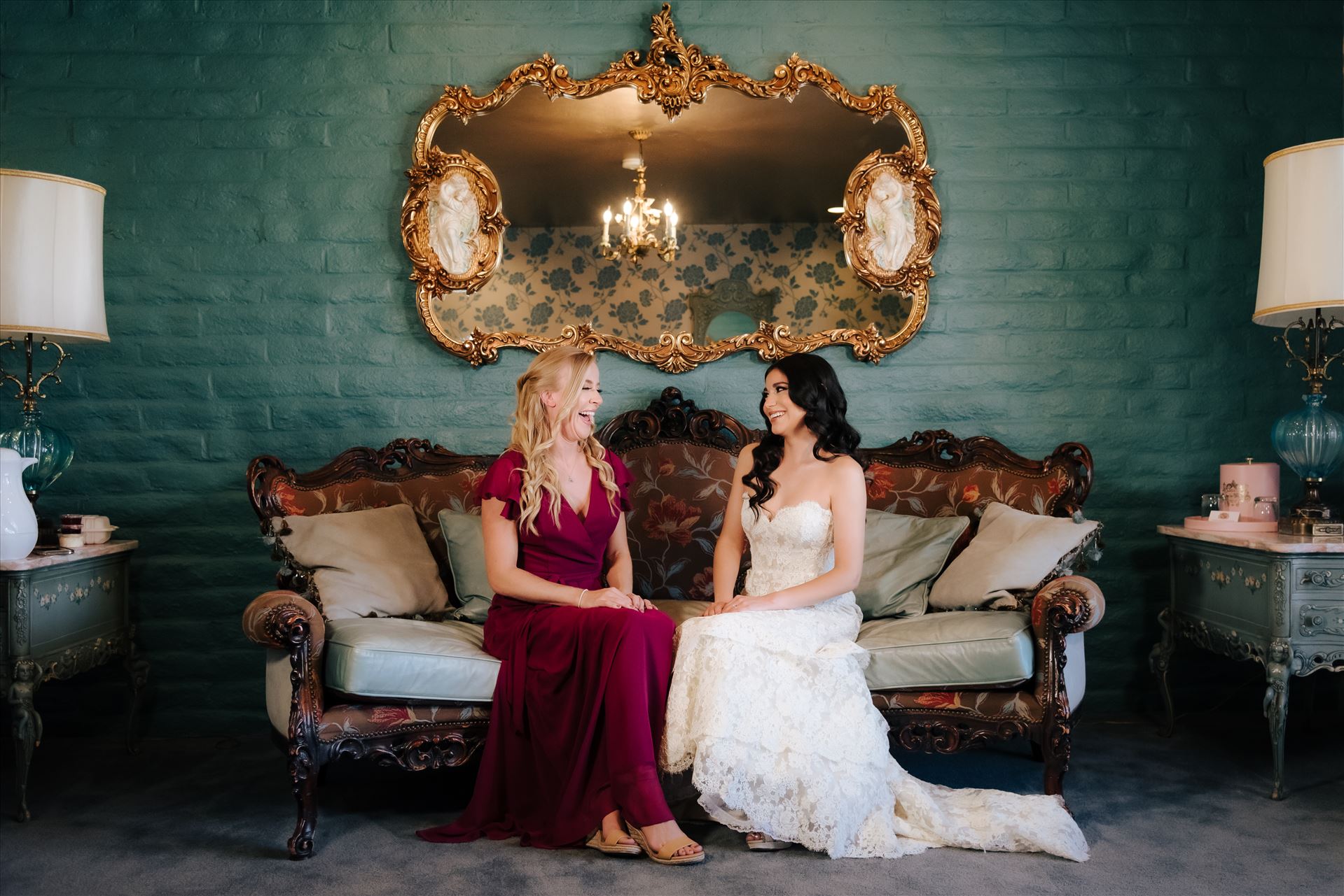 SP Gallery-1279.JPG - Mirror's Edge Photography captures Xochitl and David's magical Madonna Inn Wedding in San Luis Obispo, California. Bride and Bridesmaid in the Romance Suit on the couch. by Sarah Williams