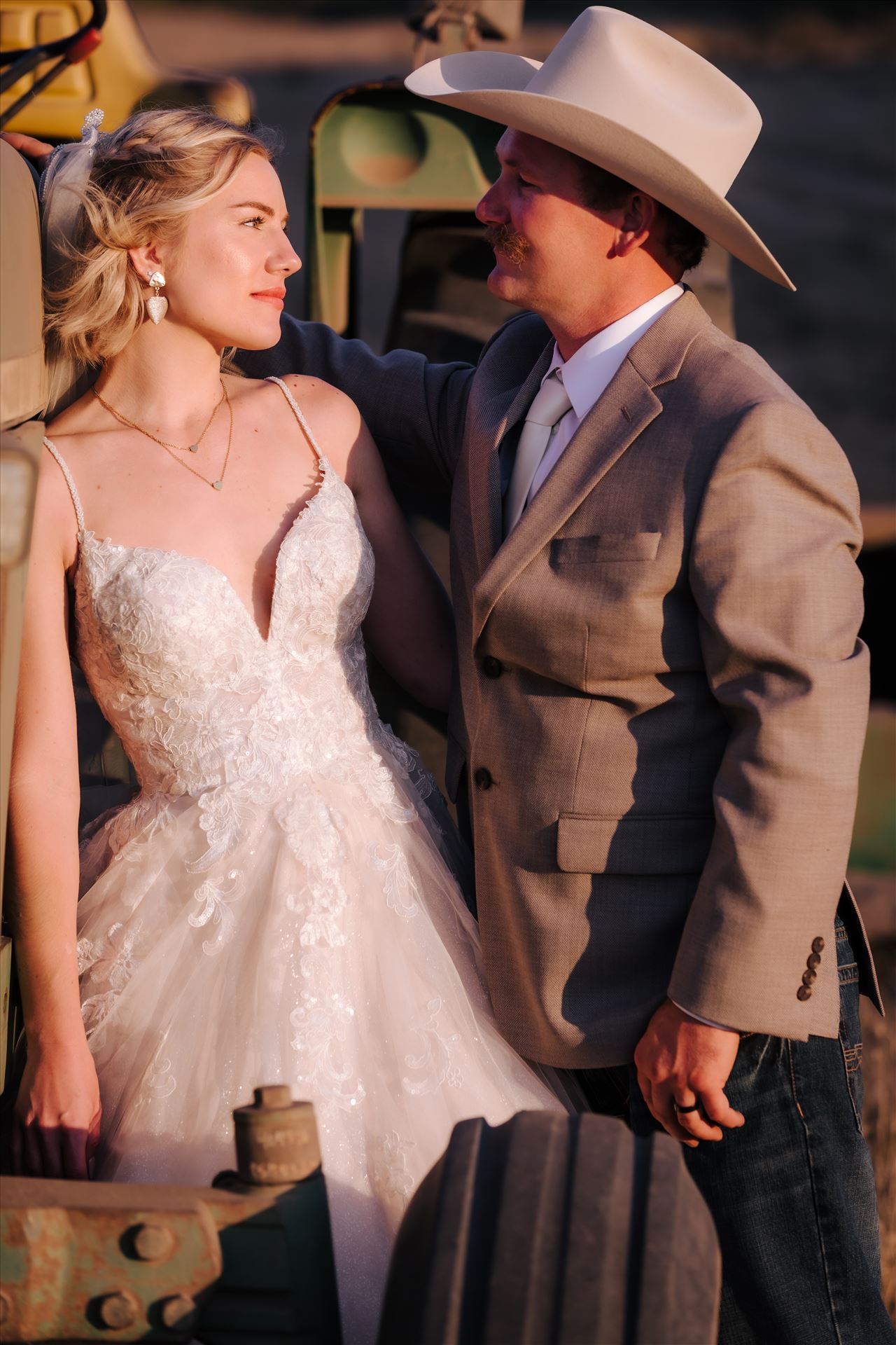 FW-1020.JPG - Sarah Williams of Mirror's Edge Photography, a San Luis Obispo and Santa Barbara County Wedding and Engagement Photographer, captures Katie and Joe's country chic wedding in Lompoc, California.  Cowboy wedding, bride and groom pose next to tractor. by Sarah Williams