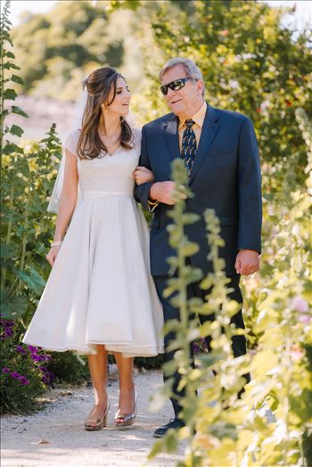 Mirror's Edge Photography captures Sarah and David's magical Madonna Inn Wedding in San Luis Obispo, California.  Bride and dad walking in the Secret Garden.
