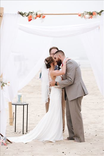 Mirror's Edge Photography a San Luis Obispo Wedding Photographer captures Sydney and Matthew's Wedding on the Beach in Grover Beach, California. Beach Butlerz set up on the Beach Bride and Groom Kissing
