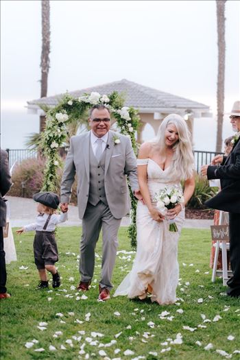 Rainy day wedding at the Shore Cliff Hotel Gazebo in Pismo Beach, California in San Luis Obispo County by Mirror's Edge Photography.  Winter Wedding vibes at the Shore Cliff Gazebo Bride and Groom on lawn.